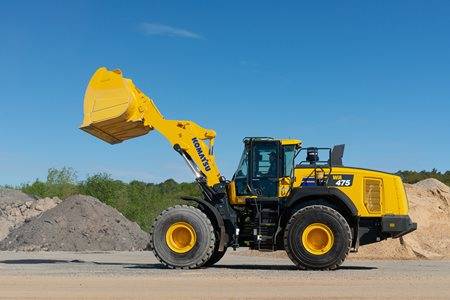 Large yellow loader machine with bucket in the air