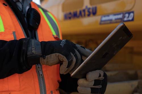 Komatsu representative using smart device onsite to provide support