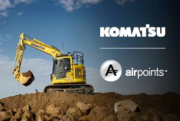 A Komatsu excavator operating on a mound of dirt, with the logos for Komatsu and Airpoints displayed on the image.